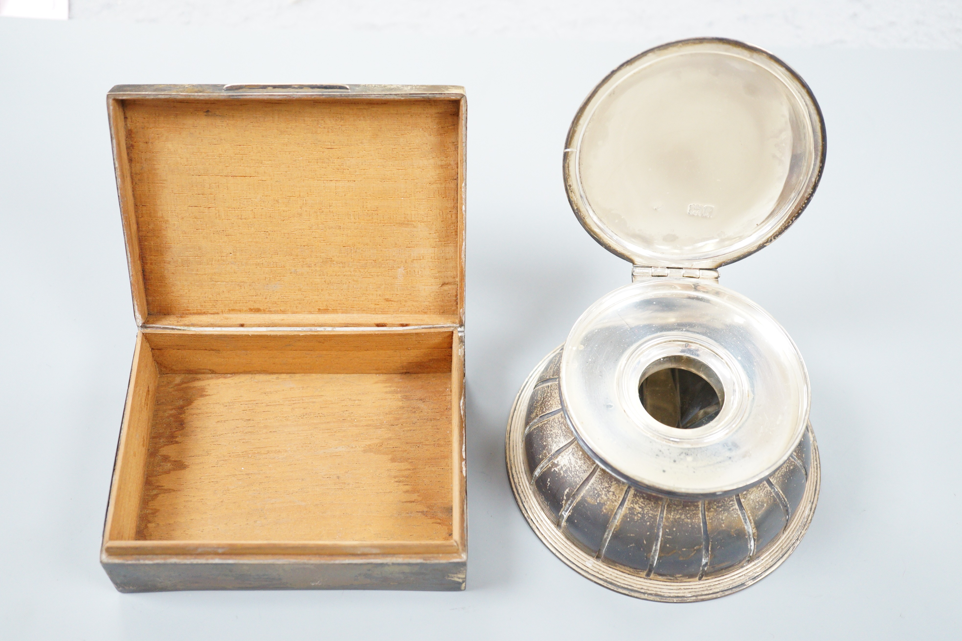 An Edwardian silver mounted circular glass inkwell by George Fox, London, 1901, diameter 11.3cm and a later silver mounted cigarette box.
